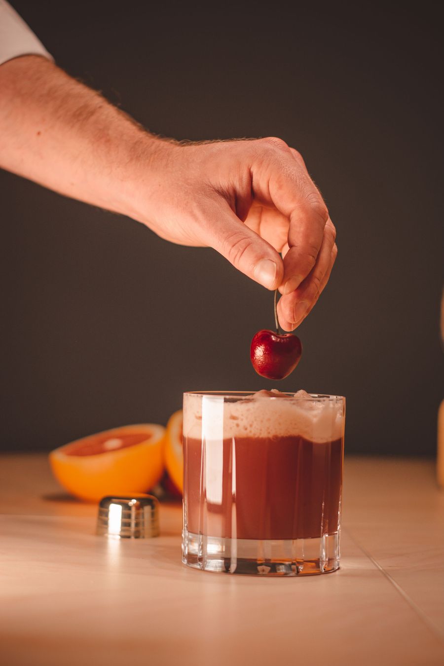 Cherry garnish placed by hand on a mocktail