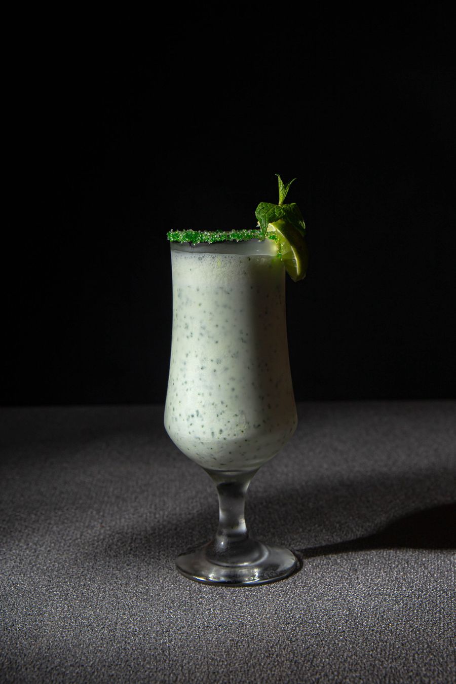 Creamy colada-style mocktail with fresh mint in a hurricane glass