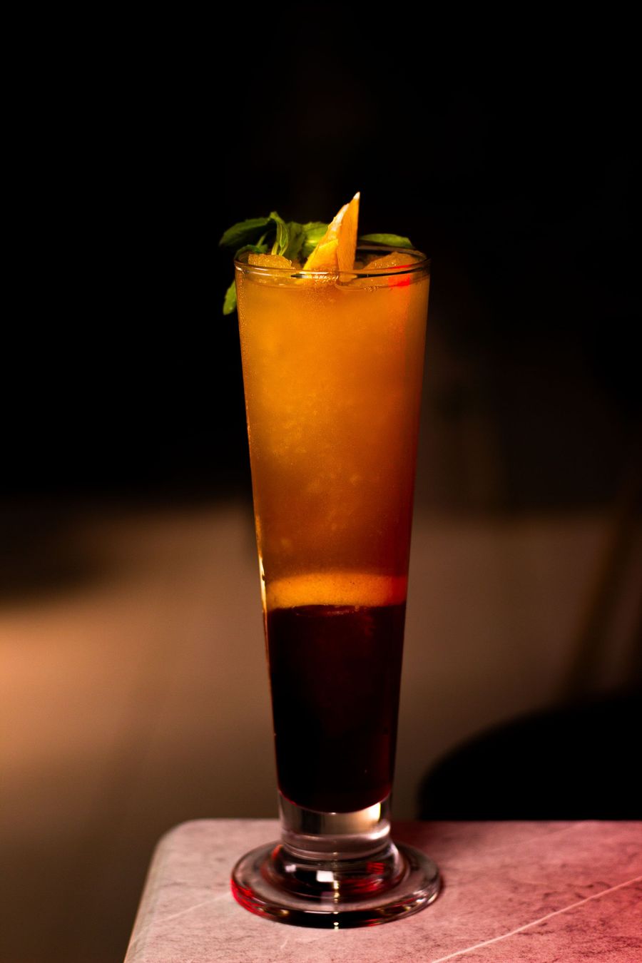 Layered orange and grenadine sunrise mocktail with an orange garnish